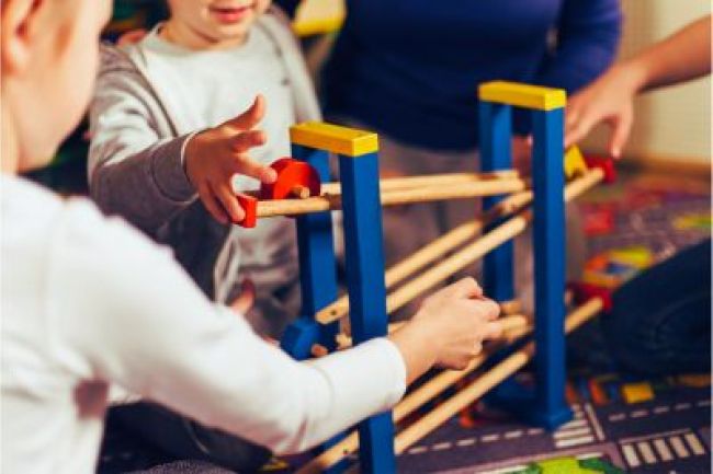 A group of children happily playing with wooden toys, fostering creativity and imagination.