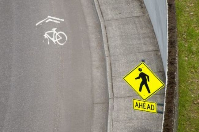 A yellow sign next to a bicycle sign.